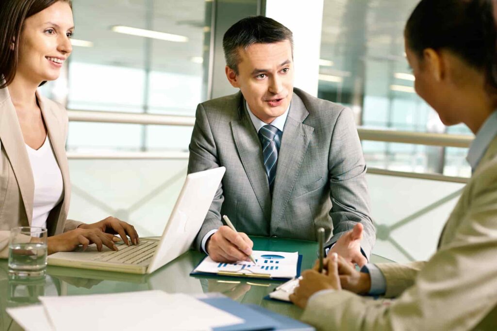 Financial advisor talking to two people in a business setting.