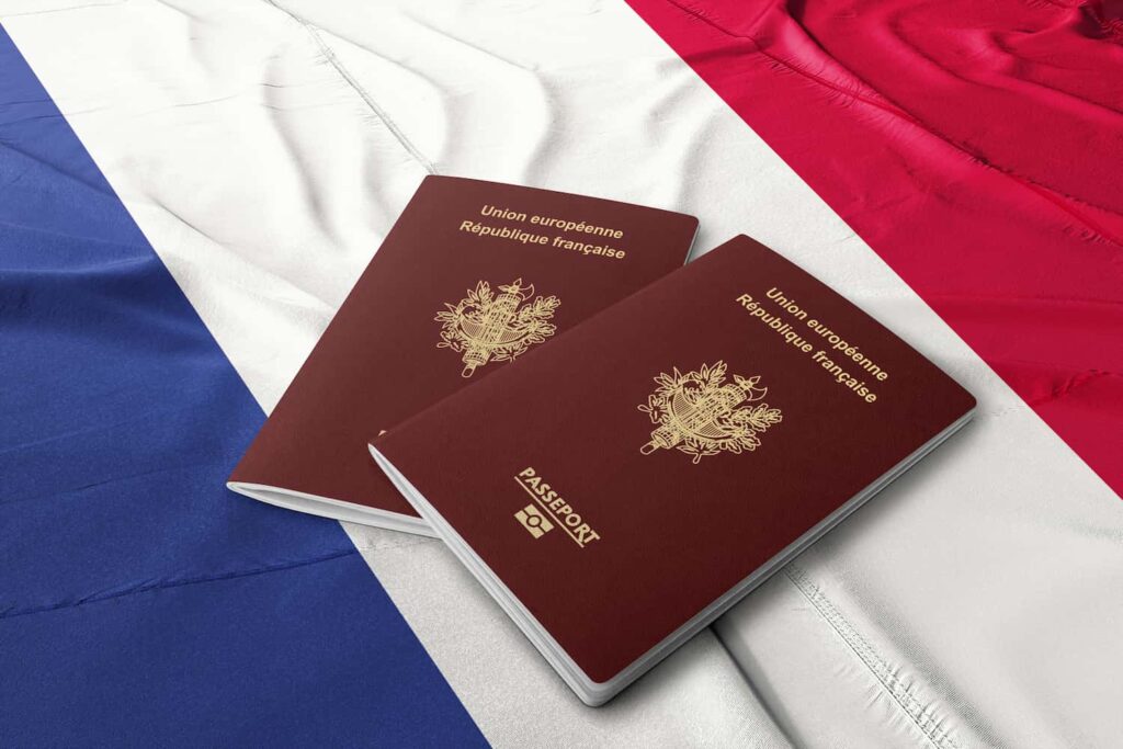 Two French passports with a French flag in the background.